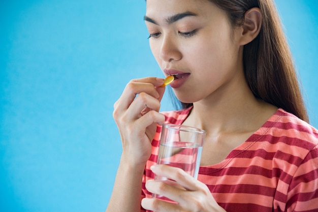 医師の指示の後の薬を飲んで若い女性