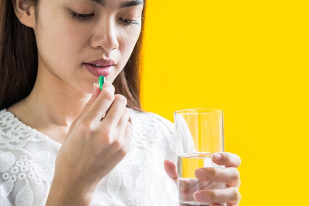 Young woman taking medicine pill after doctor order