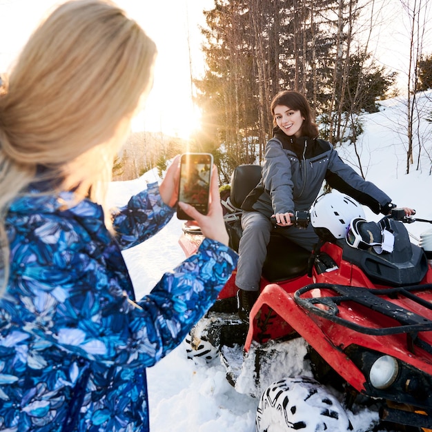 無料写真 クワッドバイクで友人の写真を撮る若い女性