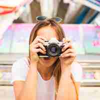 Free photo young woman taking photograph with camera