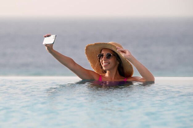 Young woman taking a selfie with her smartphone in vacation