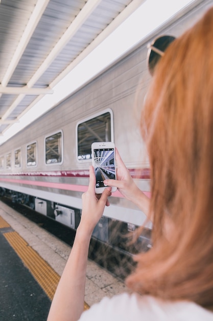 鉄道駅のショットを撮っている若い女性
