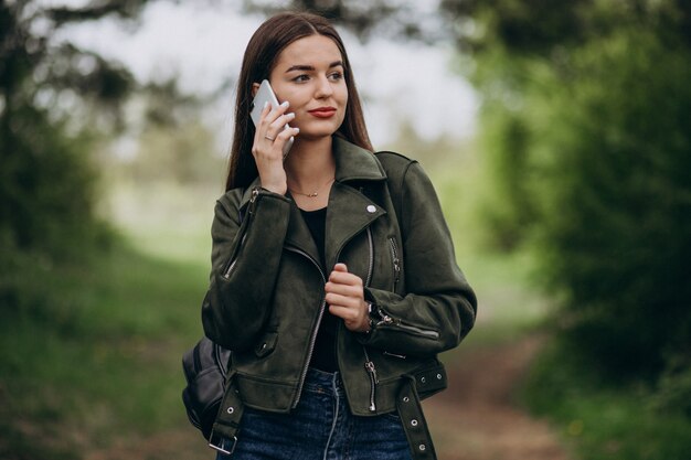 Молодая женщина разговаривает по телефону в парке