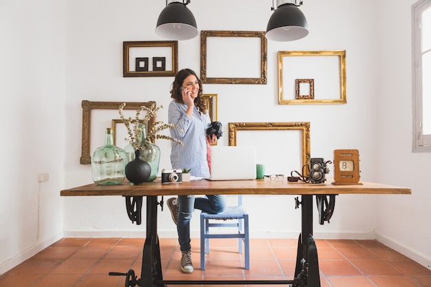 Foto gratuita giovane donna parla al telefono e con una macchina fotografica