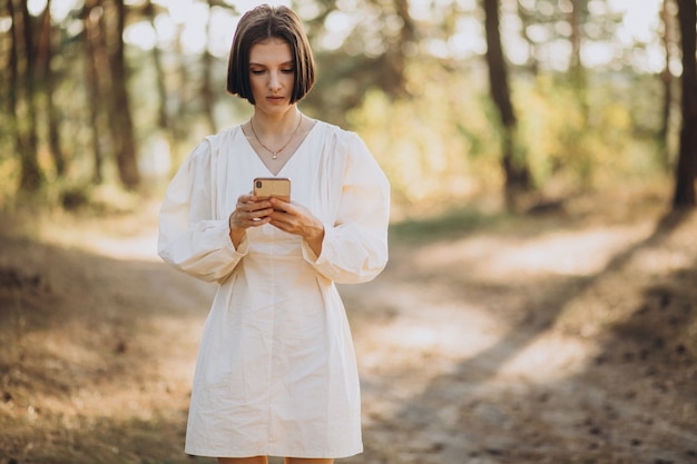 Foto gratuita giovane donna che parla al telefono nel parco