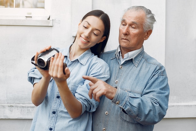 카메라를 사용하는 방법을 그녀의 할아버지를 가르치는 젊은 여자