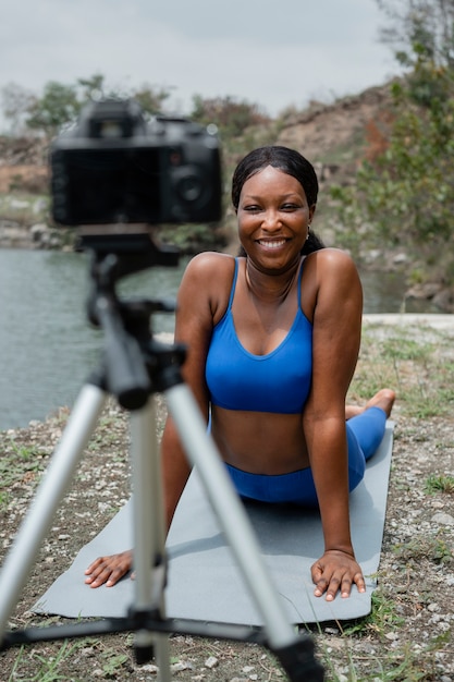 Young woman teaching a yoga pose outside