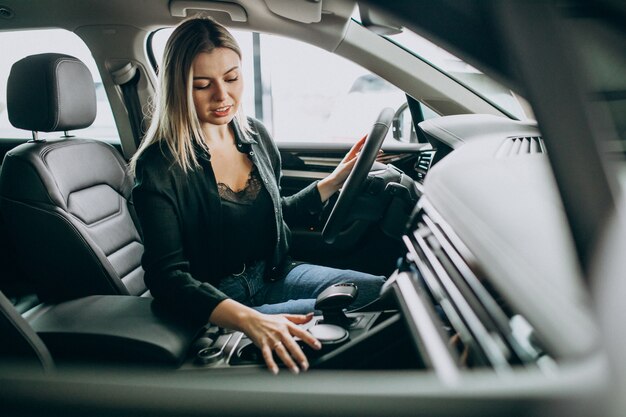 若い女性が車のショールームで車をテスト