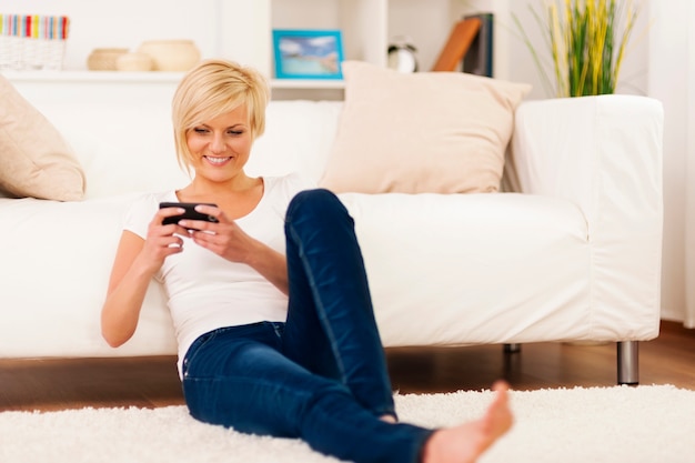 Young woman text messaging at home