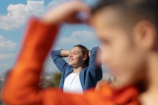 Free photo young woman through her friend's defocused hand frame