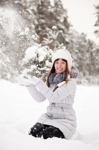 若い女性が雪を投げる