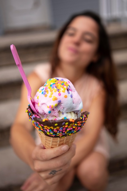Молодая женщина терпит волну жары во время еды мороженого
