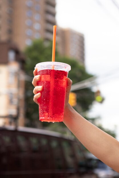 Young woman tolerating the heat wave with a cool drink