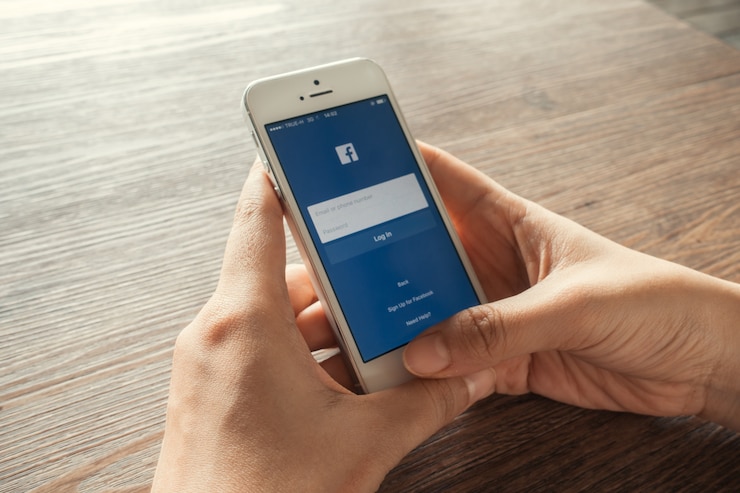 無料Photo 若い女性がスマートフォンのfacebookアイコンをタッチ