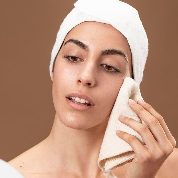 Young woman touching her face with a towel