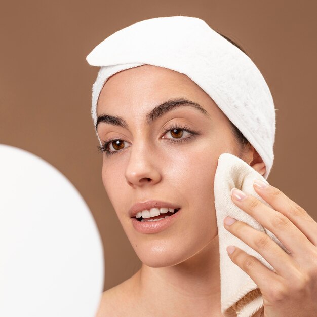 Young woman touching her face with a towel