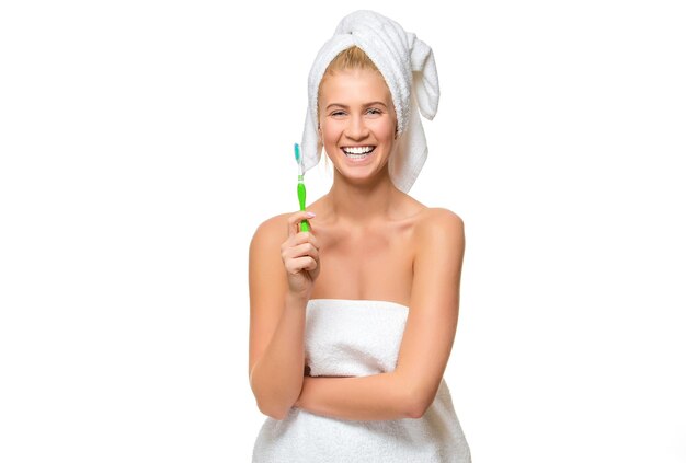 Young woman in towel with toothbrush smiling