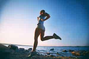 Free photo young woman training on the beach