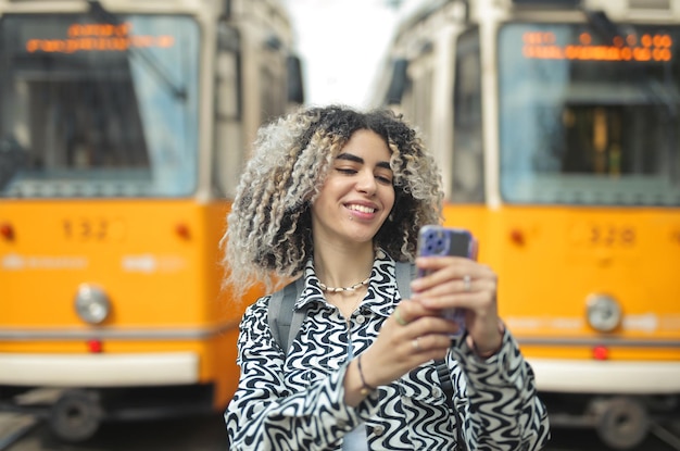 Free photo young woman in a tram station takes a selfie