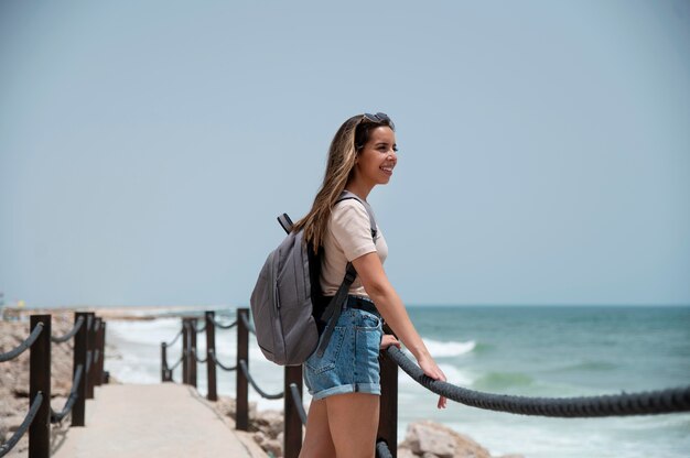 海のそばでcovidなしで旅行する若い女性