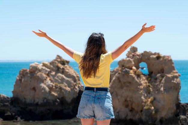 海のそばでcovidなしで旅行する若い女性