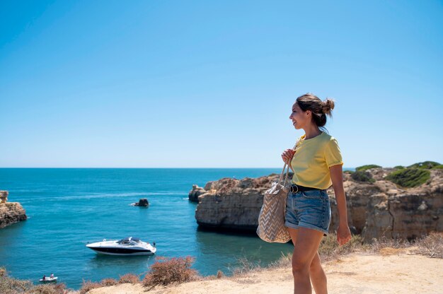 海のそばでcovidなしで旅行する若い女性