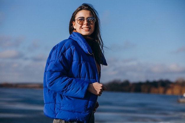 ビーチで青いジャケットの若い女性旅行者