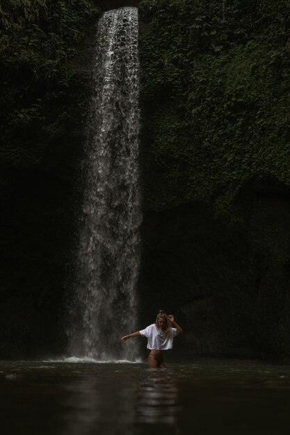 young woman travels around the island taking pictures at a waterfall