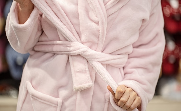 A young woman tries on a Bathrobe in a store . Close up.