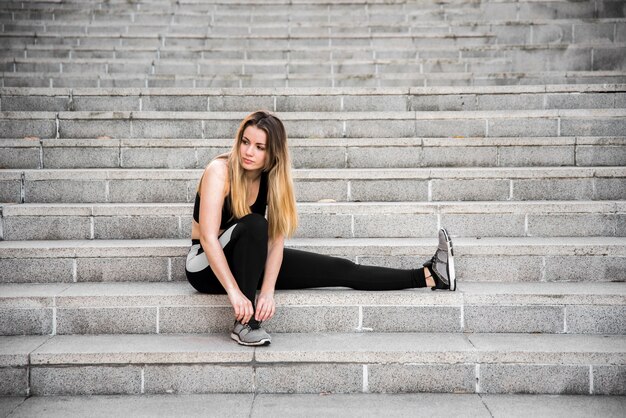 Young woman tying her sneakers