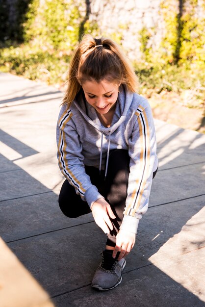 Young woman tying her sneakers