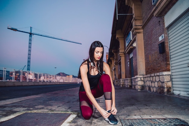 Young woman tying laces during training