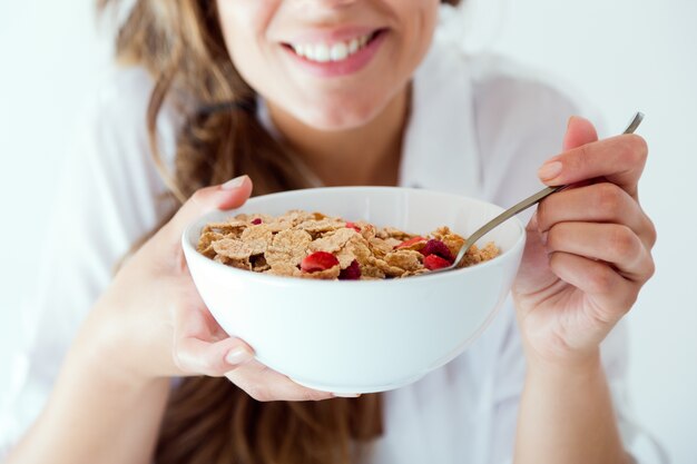 下着の若い女性が穀物を食べる。白で隔離されています。