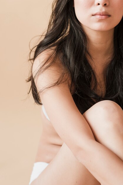 Young woman in underwear sitting with legs crossed