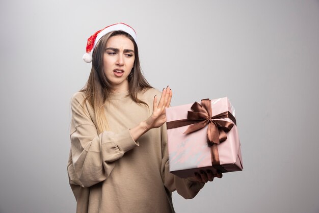 Young woman unhappy with a Christmas present .