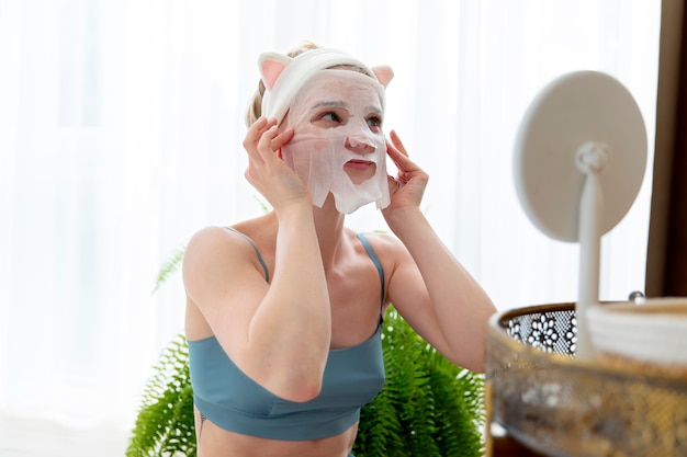 Бесплатное фото Молодая женщина, использующая маску для лица самообслуживания