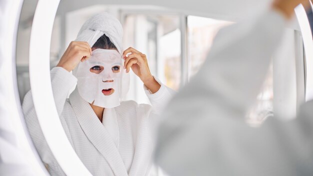 Young woman using a beauty face mask