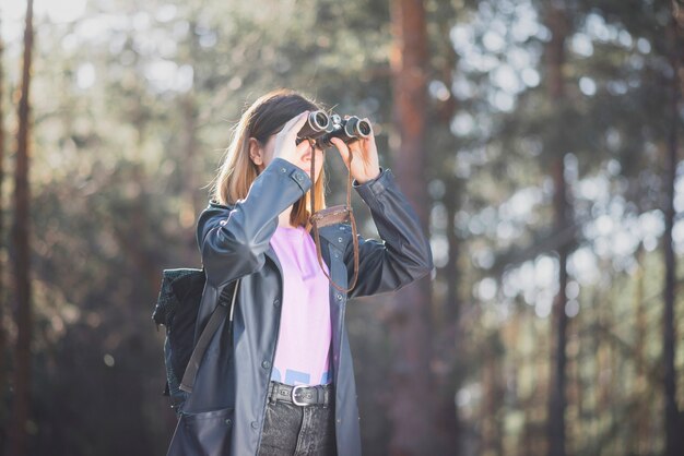 Young woman using binoculars