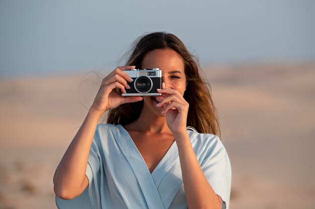 Молодая женщина с фотоаппаратом в отпуске