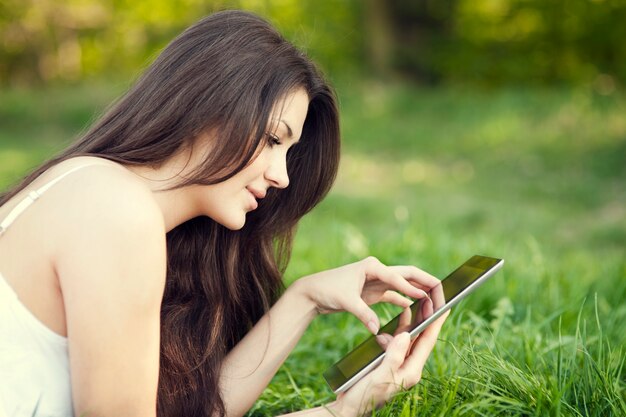 Young woman using digital tablet on meadow
