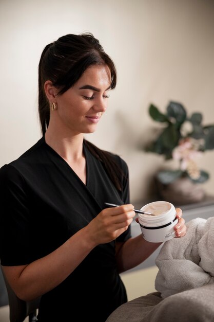 Young woman using a face treatment on her client