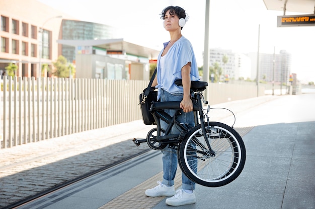 그녀의 접이식 자전거를 사용하는 젊은 여성