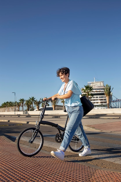 Бесплатное фото Молодая женщина, используя свой складной велосипед