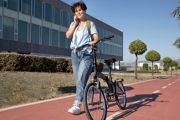 Молодая женщина, используя свой складной велосипед