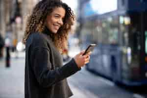 Free photo young woman using her smartphone in the city