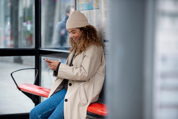 Free photo young woman using her smartphone in the city