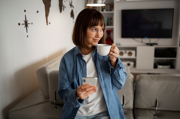 Free photo young woman using home technology