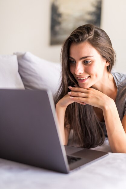 Young woman using a laptop while relaxing on the couch