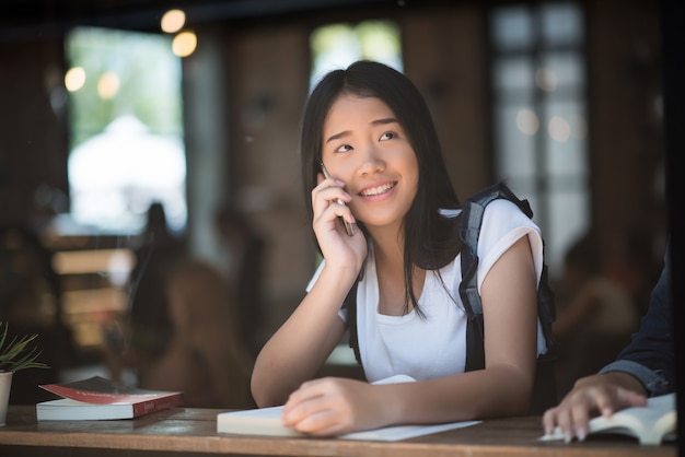 Young woman using and looking at smartphone with feeling happy