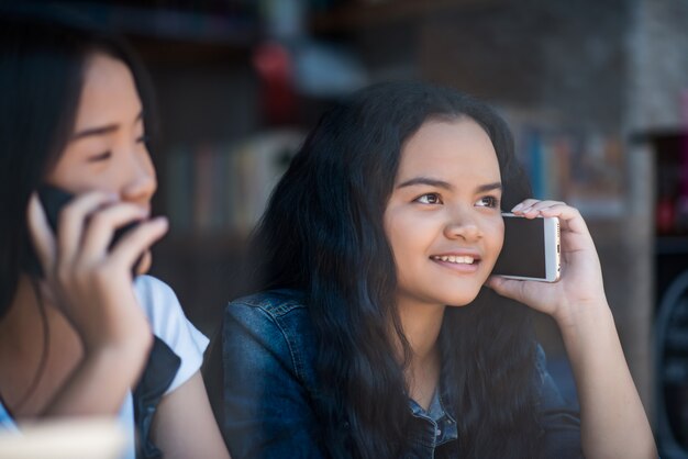 Young woman using and looking at smartphone with feeling happy